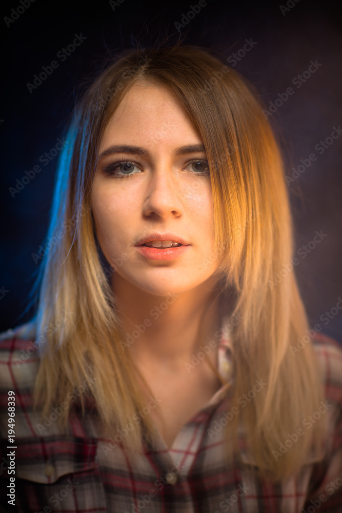 Naklejka premium portrait smiling girl on blue background in studio