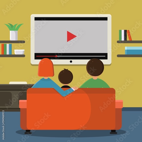 Family sitting on sofa and watching digital television on the big screen