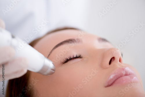 partial view of woman getting facial treatment in cosmetology salon
