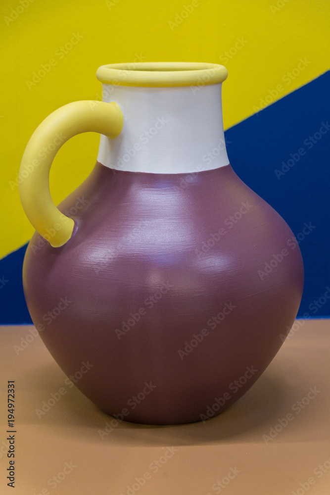 Bright ceramic multi-colored jug. Bright background. Art.