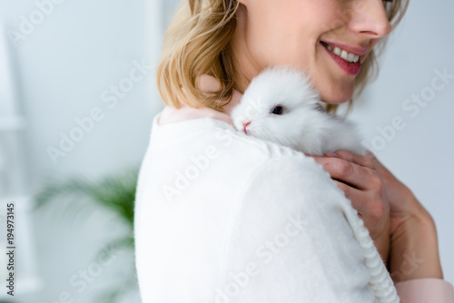 Blonde woman hugging white rabbit