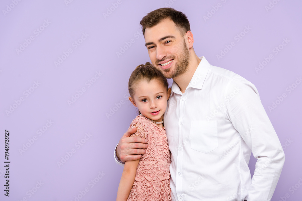 Father hugging daughter isolated on violet Father hugging daughter isolated on violet