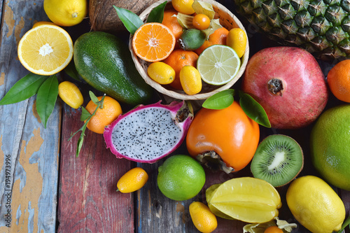 Mix of ripe tropical fruits with avocado mango, kumquat, kiwi, citrus. Superfood background. Vegetarian raw food. Copy space © Oksana_S