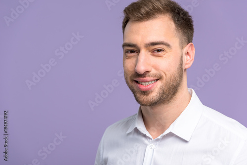 Smiling young man isolated on violet