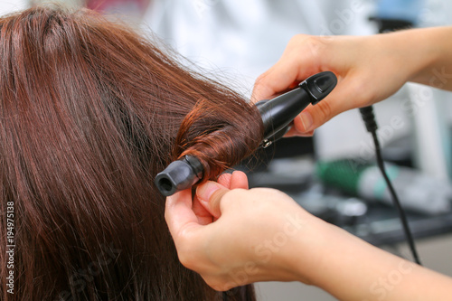 Girl in beauty salon while an hair stylist dry her hair