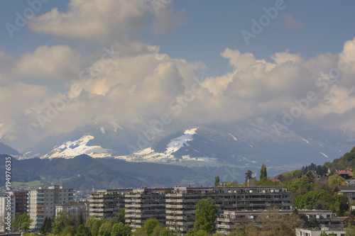 view over an alpine city to a mountain with skiing slope