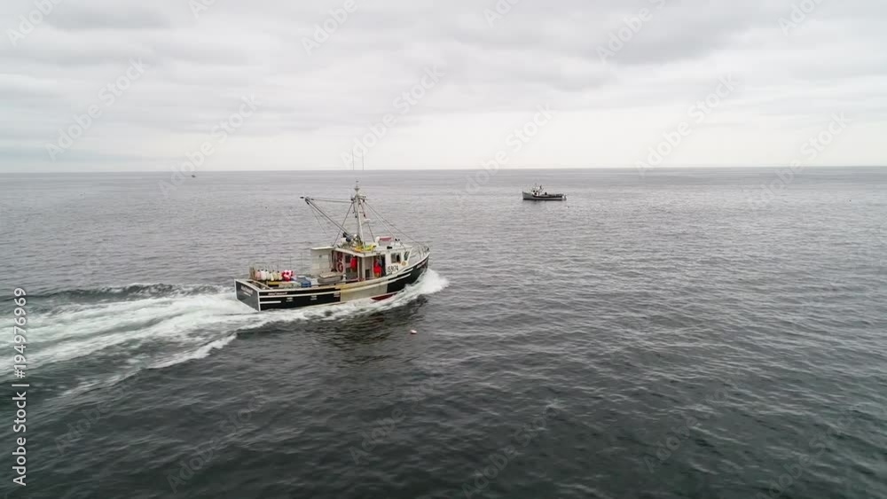 Aerial of the fisherman checking their lobster traps in ocean Aerial of the fisherman checking their lobster traps in ocean