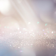 Glitter background in pastel delicate beige and pearl tones, de-focused, free space.