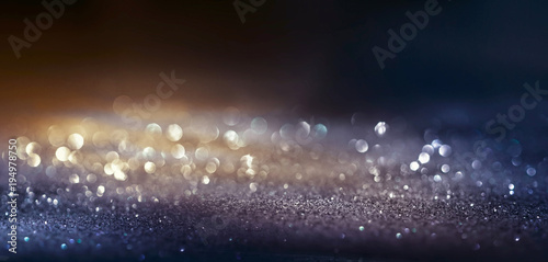 Glitter dark background black and golg color , de-focused, macro. Sparks fall and sparkle in ray of light, free space, panoramic. photo