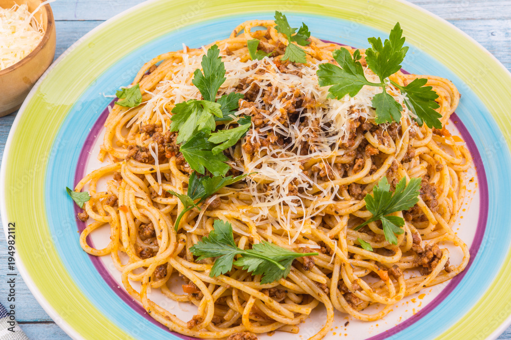 Spaghetti bolognese with cheese and celery leaves - top view Spaghetti bolognese with cheese and celery leaves - top view