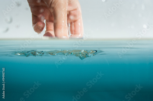 Hand greift ins Wasser zur Abkühlung oder Inspektion