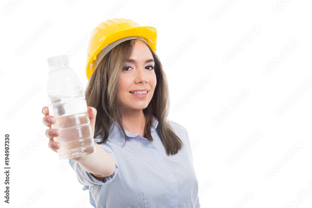 Pretty female constructor offering bottle of water. Pretty female constructor offering bottle of water.