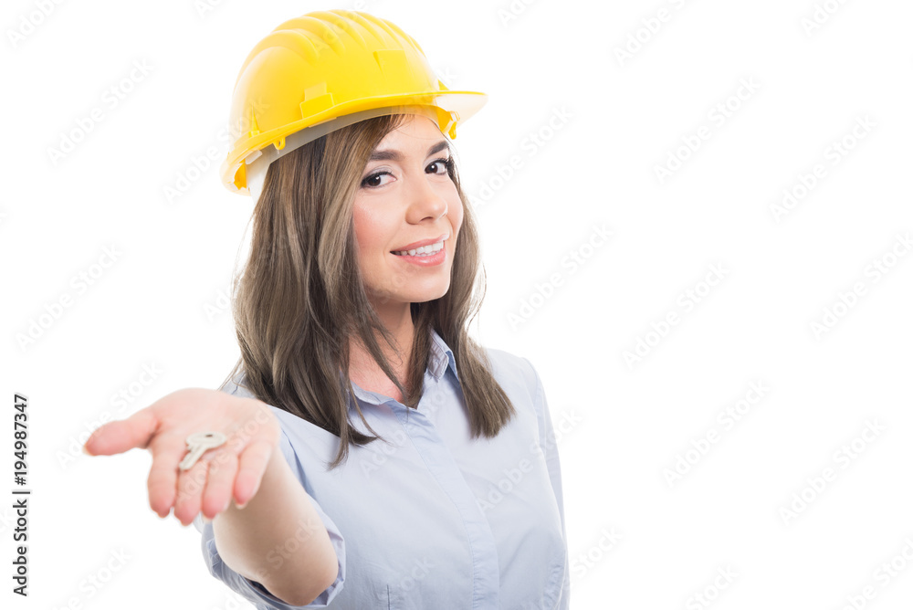 Portrait of female constructor handing door key. Portrait of female constructor handing door key.