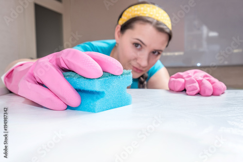 housewife washes the table in the kitchen