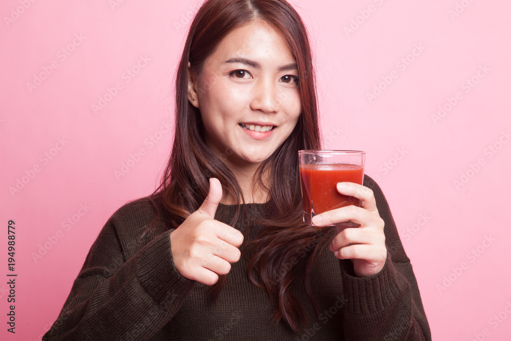 Young Asian woman thumbs up with tomato juice. Young Asian woman thumbs up with tomato juice.