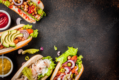 Assortment of different homemade Vegan Carrot Hot Dogs, with fried onion, avocado, chili, mushrooms, tomatoes and beans, dark rusty background copy space top view © ricka_kinamoto