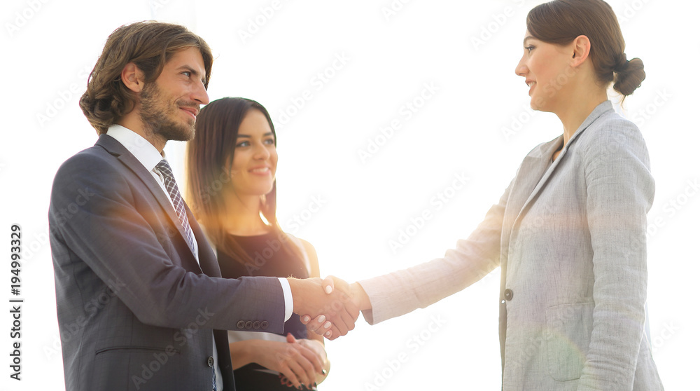Businesspeople shaking hands against room with large window loo Businesspeople shaking hands against room with large window loo