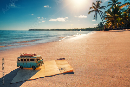 Fototapeta Naklejka Na Ścianę i Meble -  Vintage miniature van and old treasure map on the tropical beach at sunrise, travel concept