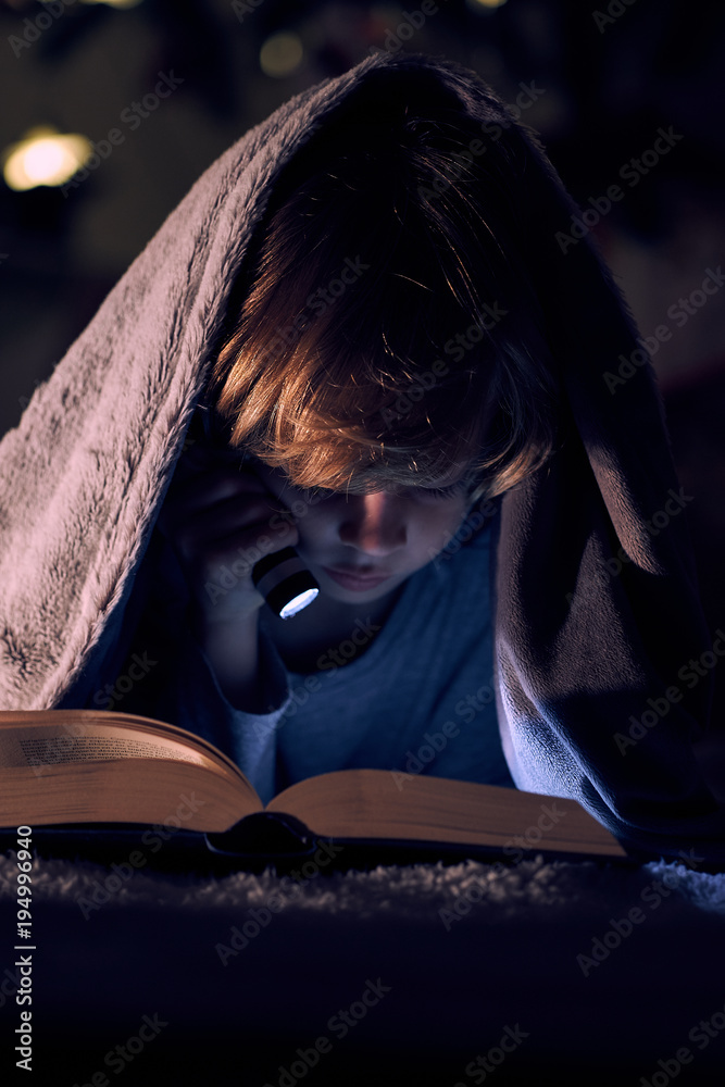 Boy reading book with flashlight Boy reading book with flashlight