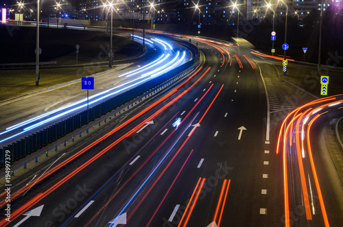 Light trails on highway at night, long exposure abstract urban background