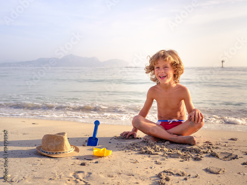 Cheerful boy playing with sand
