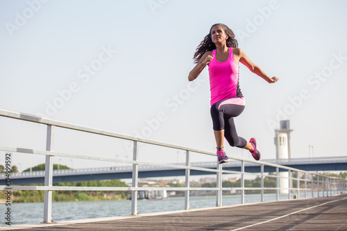 Mujer joven corriendo y saltando al aire libre con copy space en el cielo