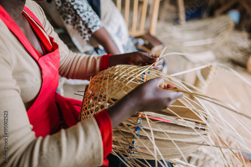 woman weaving basked out of bamboo in Rwanda Africa photo