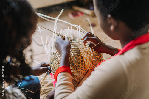 Woman weaving basked out of bamboo in Rwanda Africa photo