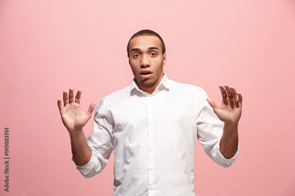 Naklejka premium The young attractive man looking suprised isolated on pink
