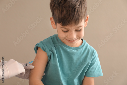 Doctor vaccinating little c...