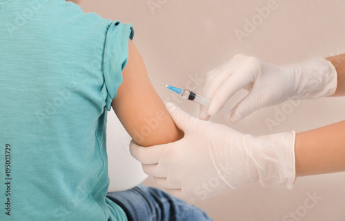 Doctor vaccinating little c...