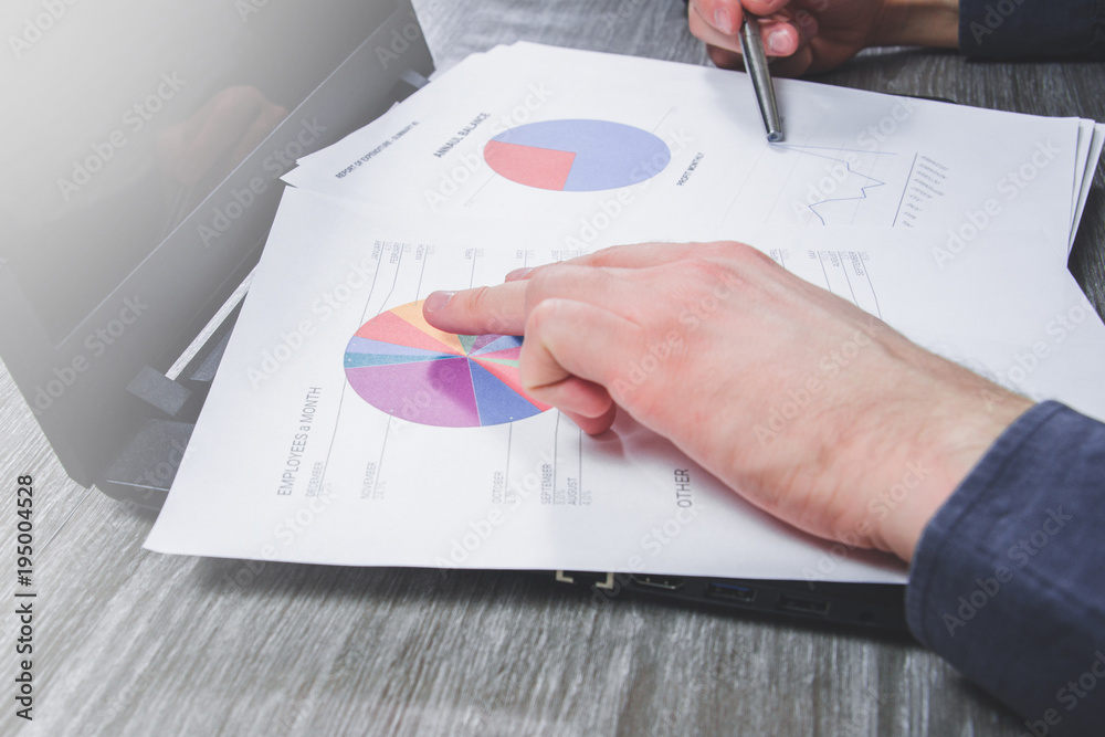 Work at the computer, the man checks the data. The businessman controls expenses and profits, checks reports, charts. Annual balance sheet, annual report.