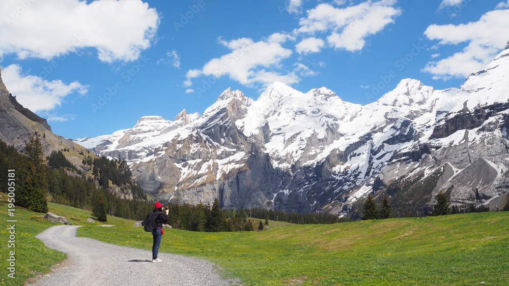 Traveler taking picture of Alps mountain view on the way to Oeschinen lake, Switzerland, May 2017