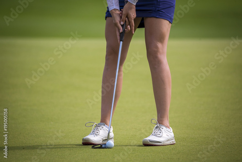 golfer pushing golf to hole on golf course 