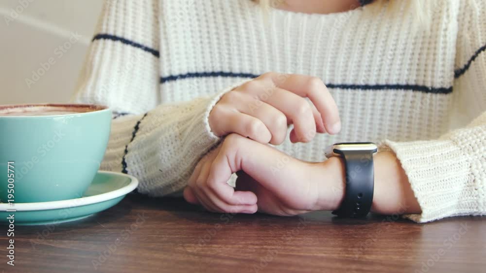 Woman using typing on smart watch in cafe Woman using typing on smart watch in cafe