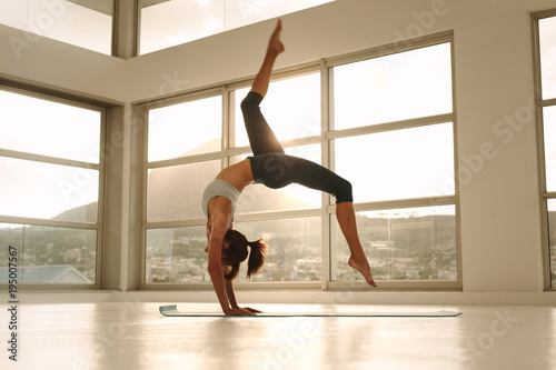 Sporty girl doing handstand yoga asana