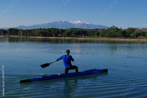 canoé et paddle qui rame sur le lac et montagne