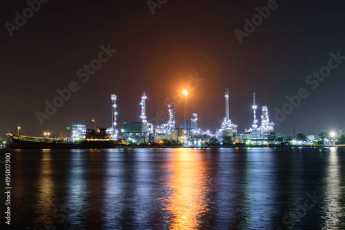 Oil refinery at the river in night time / Big Factory in night time
