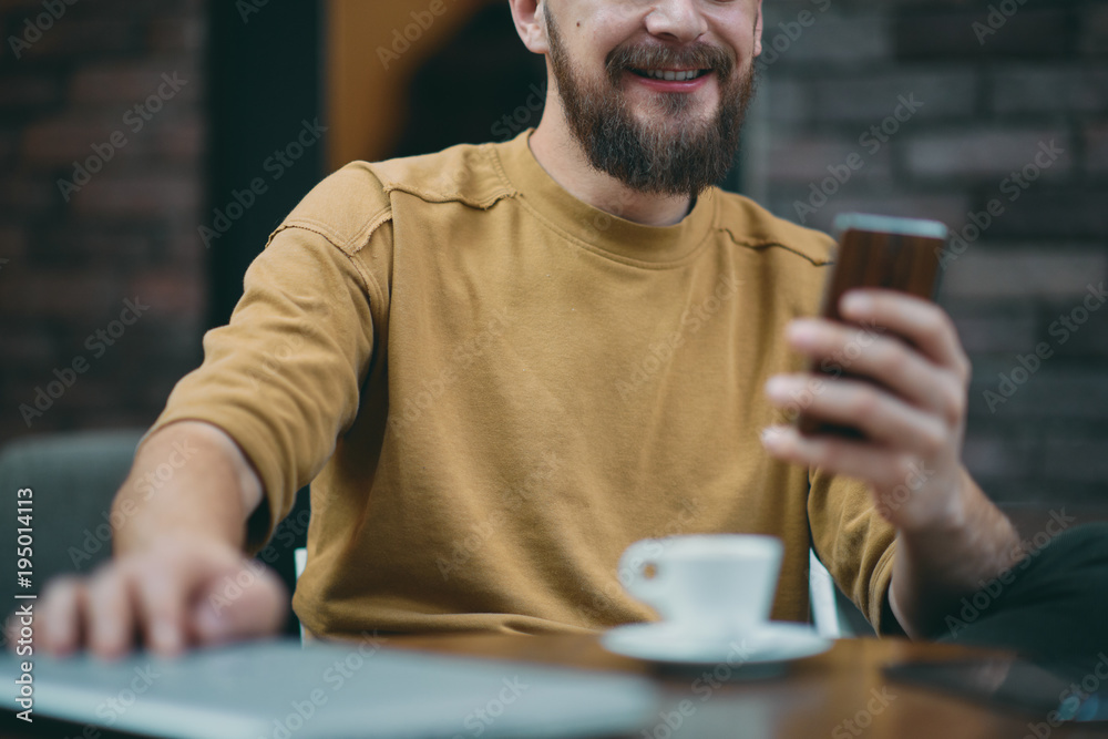 Young man sitting in cafe and using smart phone. Young man sitting in cafe and using smart phone.