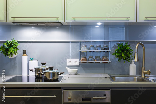 Modern kitchen in grey colors at home with kitchenware