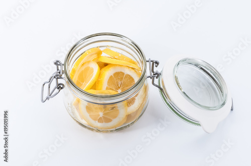 Lemon sliced in a jar filled with sugar, top view.