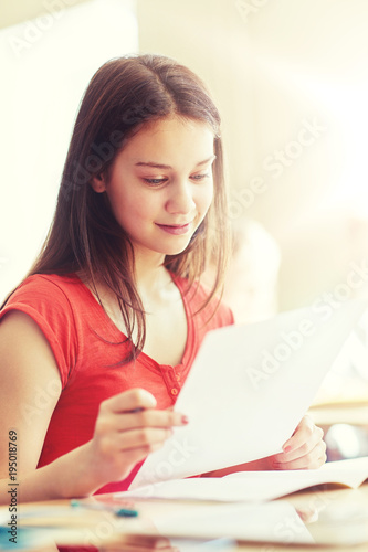 happy student girl with test paper at school