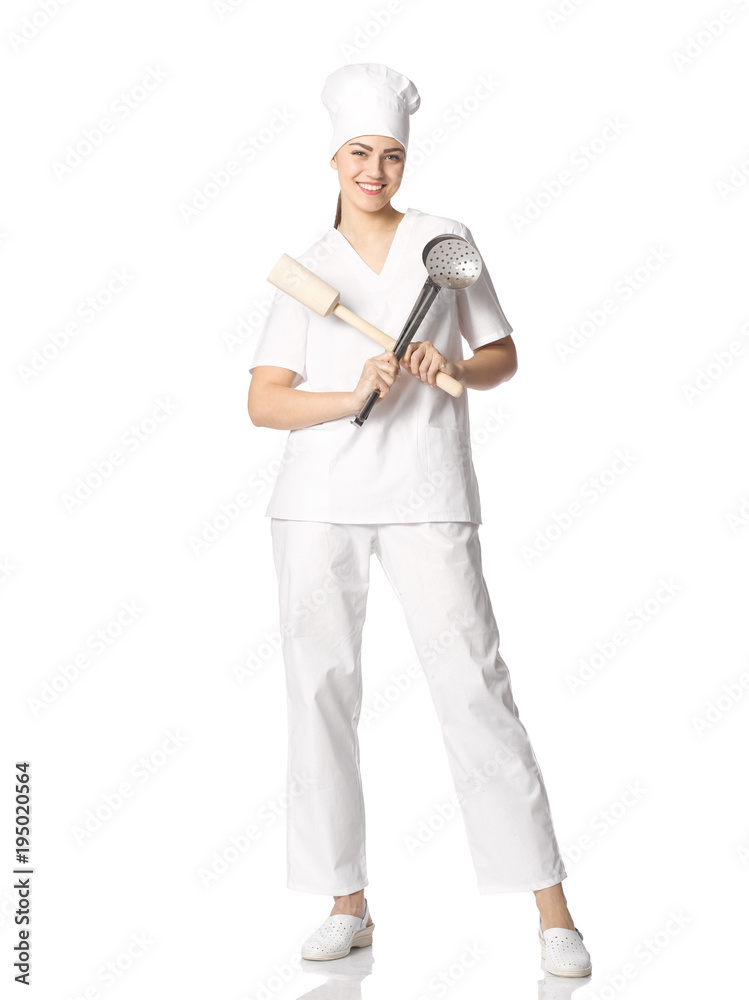 Portrait of a young female student in a chef's clothes with crossed kitchen utensils in her hands isolated on white background. Portrait of a young female student in a chef's clothes with crossed kitchen utensils in her hands isolated on white background.
