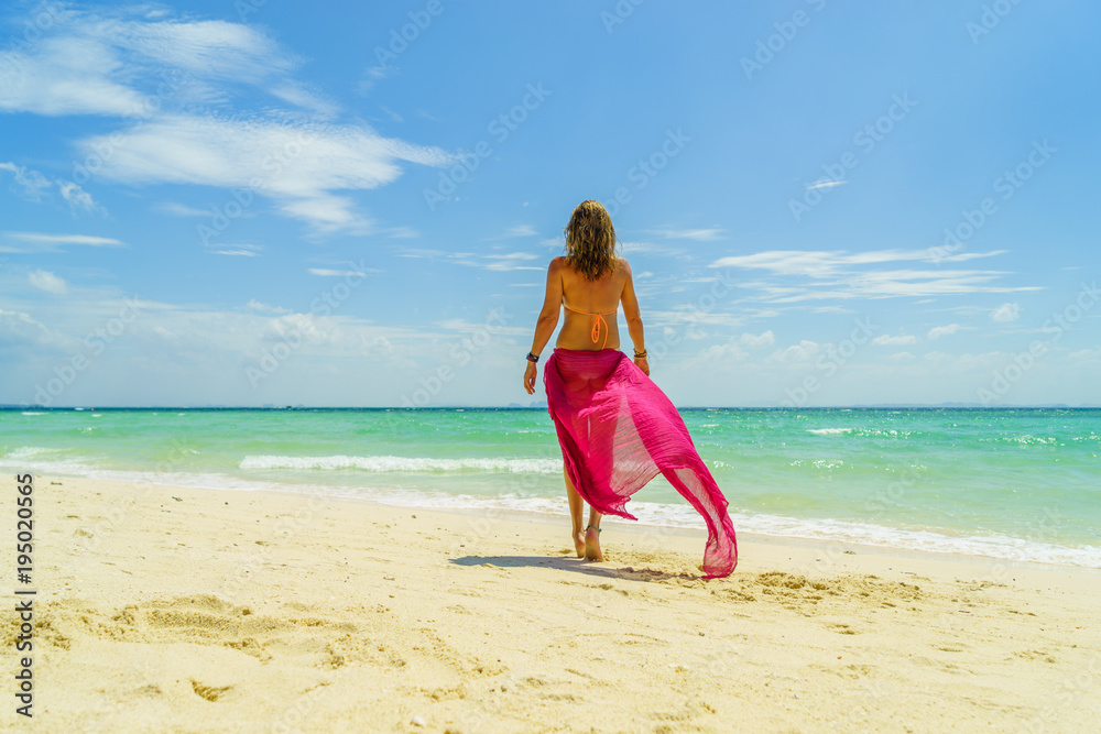 Woman with pink sarong at the beach in Koh Poda island Thailand