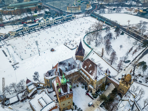 Budapest, Hungary - Aerial skyline view of snowy Vajdahunyad Castle with City Park Ice Rink and Heroes' Square at background on a winter morning