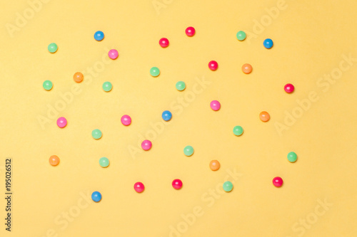 Sweet colorful chocolate candy on yellow background