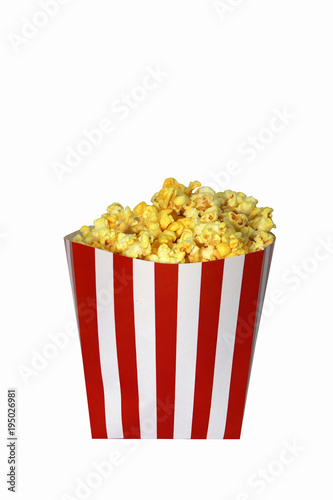 Popcorn in the red and white paper box on white background. Clipping path. It is the corn of a variety with hard kernels that swell up and burst open with a pop when heated.
