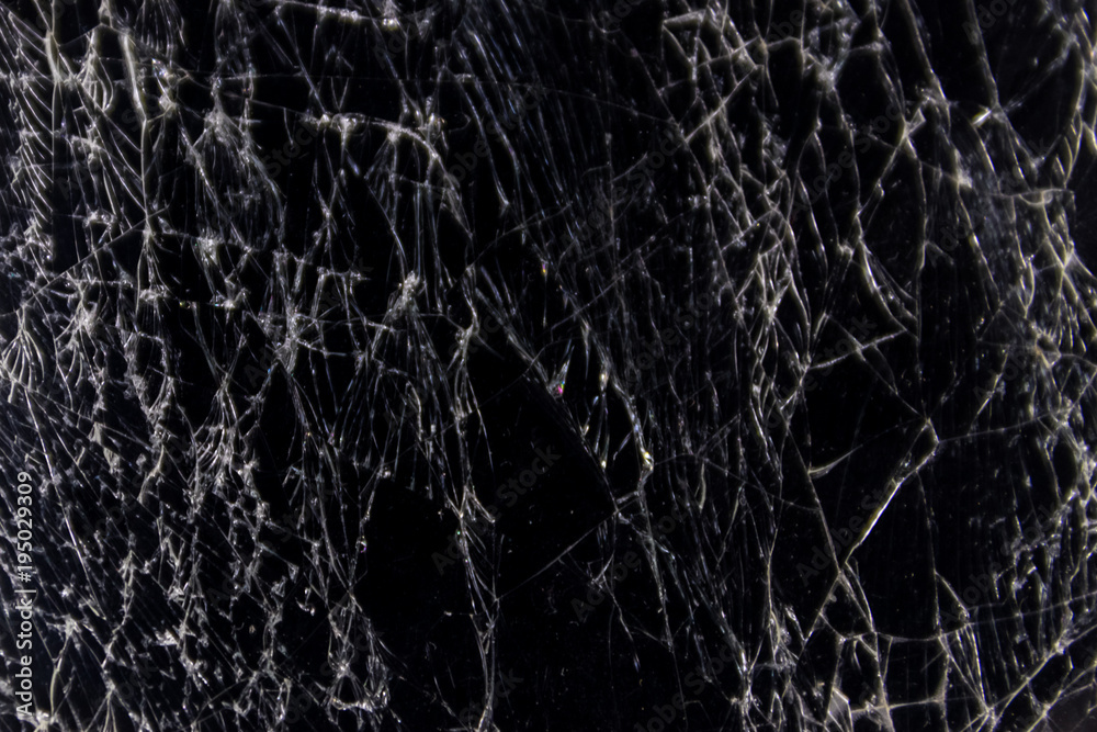 Cracked smart phone screen close-up. Broken glass texture background
