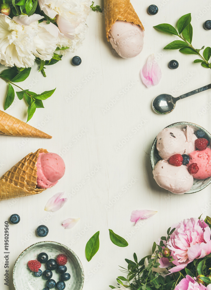 Φωτογραφία Flat-lay of pink strawberry and coconut ice cream scoops, sweet cones and peony flowers bouquet over white background, top view, copy space, vertical composition