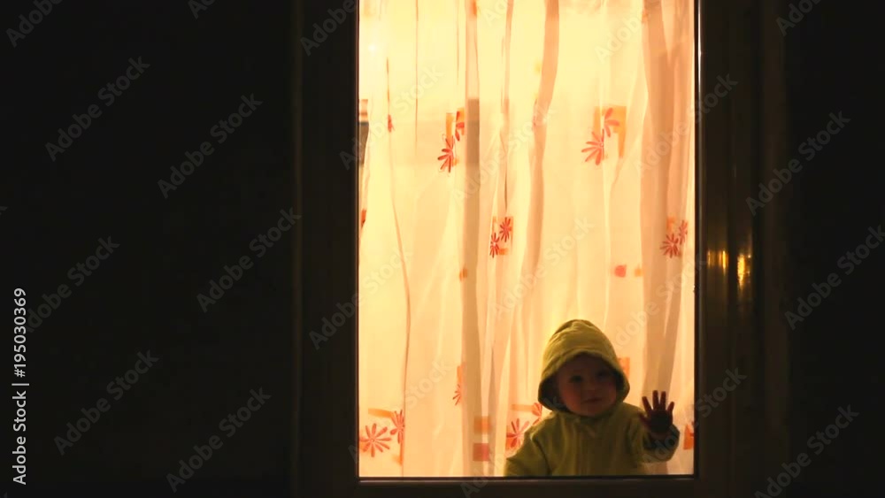 Baby watching outside in the night from a back lit window Baby watching outside in the night from a back lit window